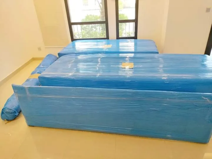 أجزاء سرير مغلفة بالنايلون الأزرق في غرفة نوم