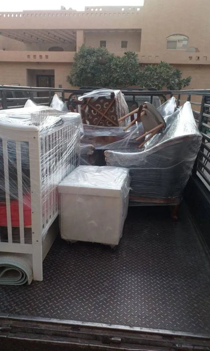 سرير أطفال وكنب مغلف بالنايلون على صندوق شاحنة في نقل عفش داخل الرياض