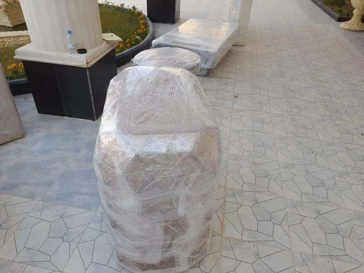 تغليف اثاث بطبقات النايلون حول طاولة دائرية على أرضية فسيفساء